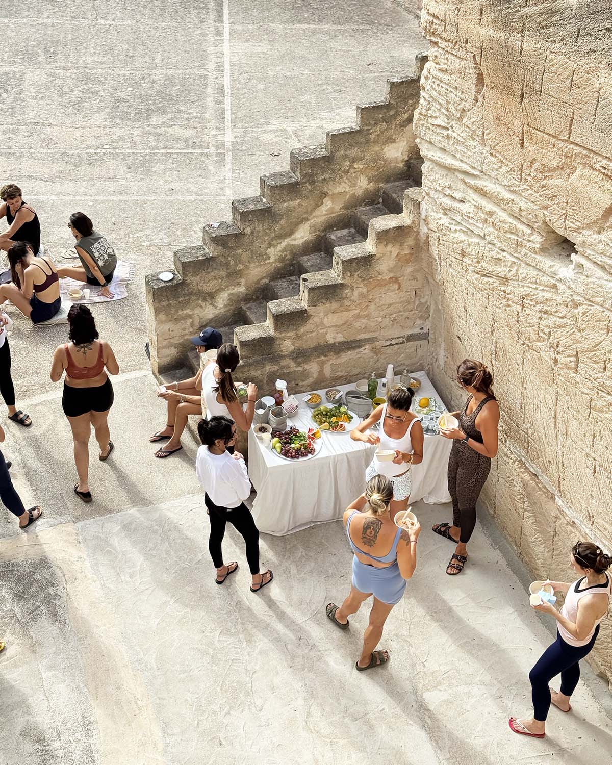 Momento conviviale nella cava di tufo di Mae a Favignana con tavolo allestito e persone riunite nello spazio esterno.