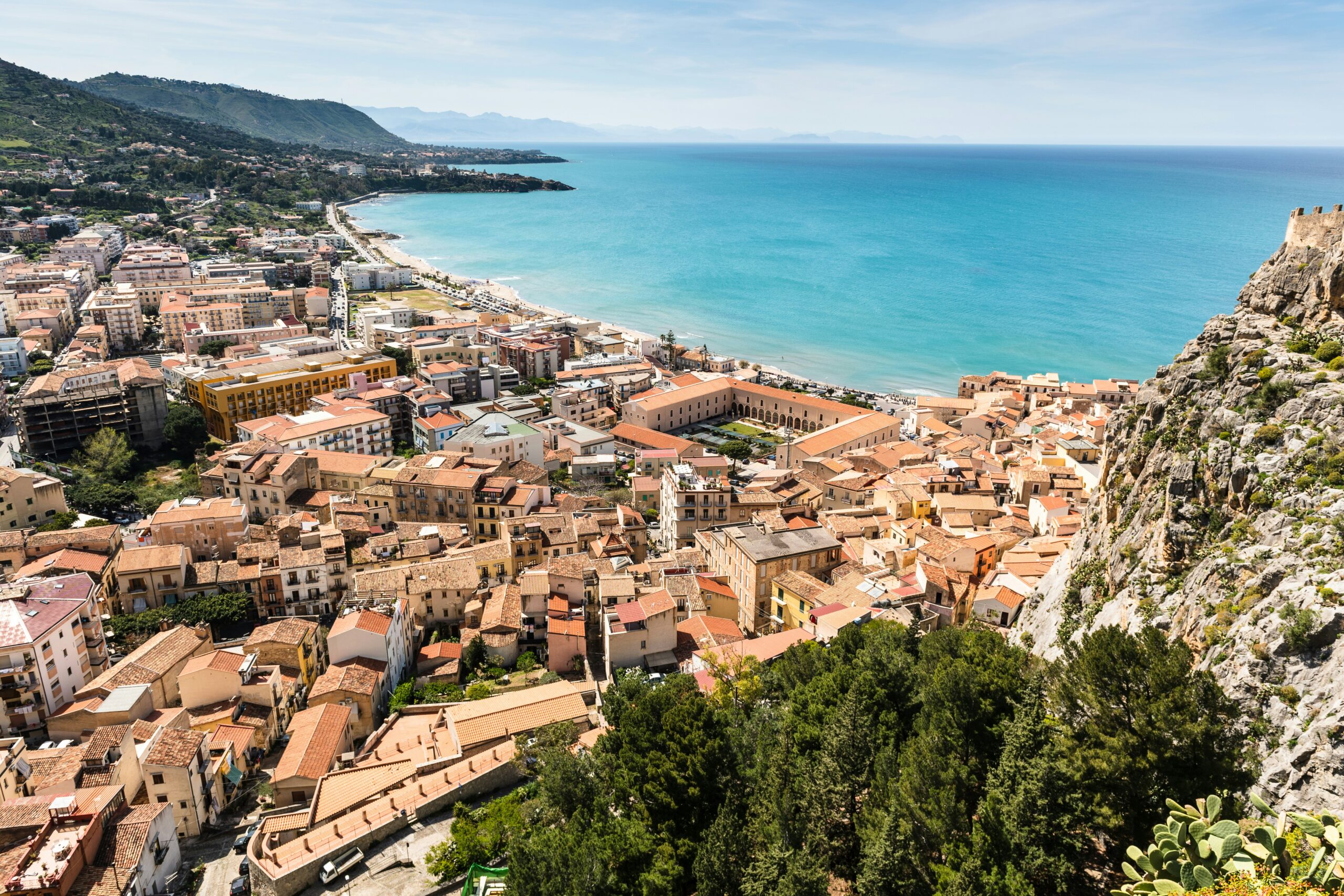 Scorcio della costa di Favignana vicino alla spiaggia del Bue Marino, con mare turchese e barca all'orizzonte